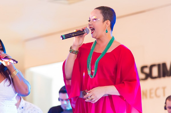 Cantora Fátima Silva aparece cantando, com roupa vermelha
