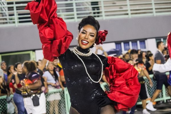 Uma mulher negra, a Rainha da bateria Raissa Santos, da Andança de Ciganos sorrindo na avenida durante ensaio técnico