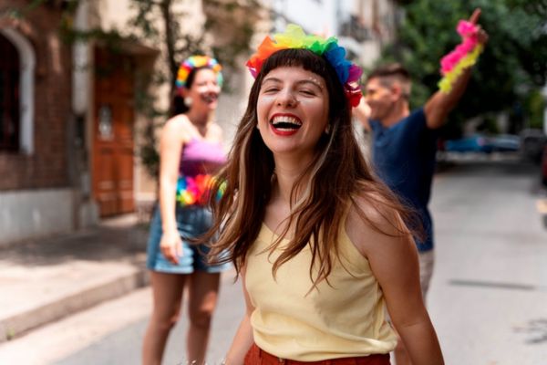 Mulher sorrindo com uma tiara colorida, pronta para carnaval