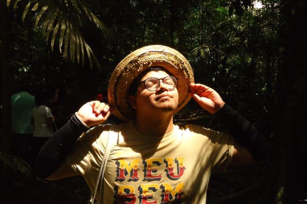 Mano Jabutt em destaque, com os braços para cima, com um chapéu de palha na cabeça