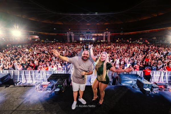 Cantores sobre um palco e ao longe um público enorme