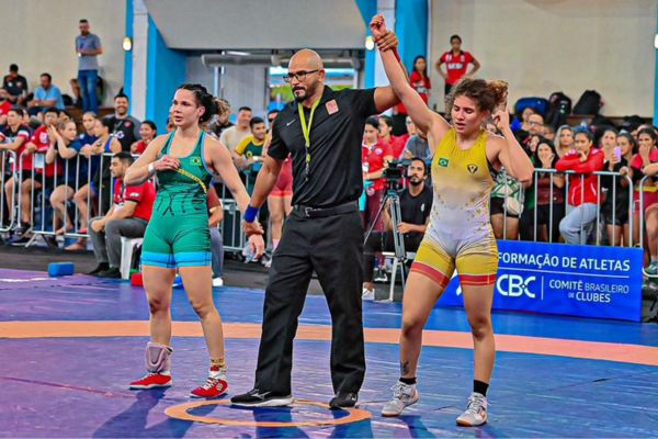 Viviane de Almeida com sua adversária, além do árbitro, levantando seu braço, indicando sua vitória