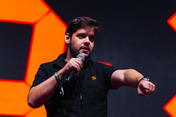 Fernando Miranda, uma das atrações nacionais do evento, com camisa preta, microfone na mão, apontando para a plateia