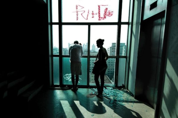 Cena do filme Pele de Vidro, onde aparecem duas pessoas em uma parede de vidro