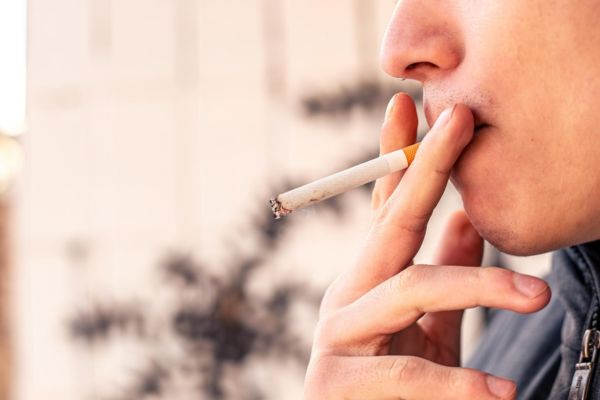 Pessoa fumando, alerta sobre tabagismo